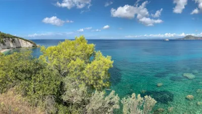 Mare cristallino e costa verdeggiante in Toscana, con vista panoramica su acque calme e colline circostanti