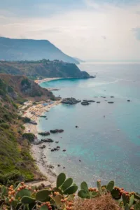 Vista panoramica sulla costa della Calabria, con scogliere, spiagge bianche e acque trasparenti circondate da vegetazione mediterranea
